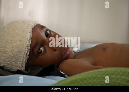 A young boy lies in the AMISOM Level II hospital on July 8 after having been wounded during fighting in Kismayo, Somalia. AU UN IST PHOTO / ILYAS A. ABUKAR Stock Photo