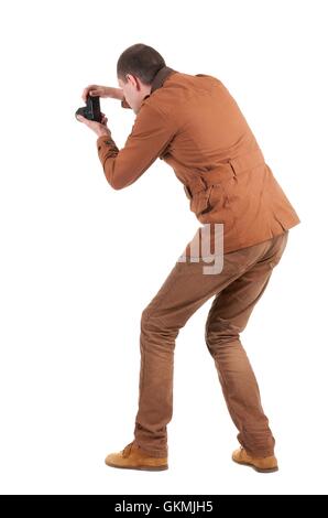 Back view of man photographing.   stylishly dressed in casual clothes photographer. Rear view people collection.  backside view Stock Photo