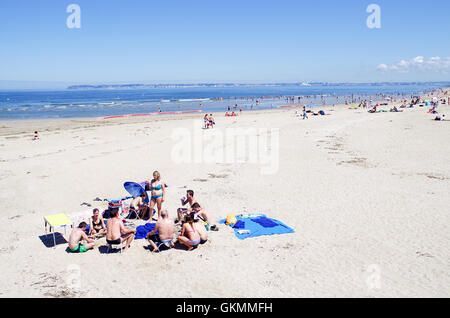 A gang of friends partying on an empty sandy beach in Trouville-sur-Mer Stock Photo