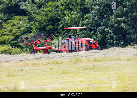 Tractor pulling a Rotary Rake Stock Photo