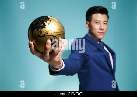 Young business man holding the globe Stock Photo