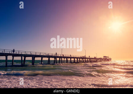 People  walking along the  Henley Beach Jetty on a warm sunny evening. Color-toning applied Stock Photo