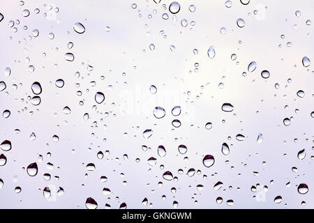 Retro toned photo of raindrops on a dusty glass. Stock Photo