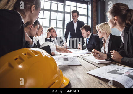 Business people group on meeting with construction engineer architect looking building blueprint Stock Photo