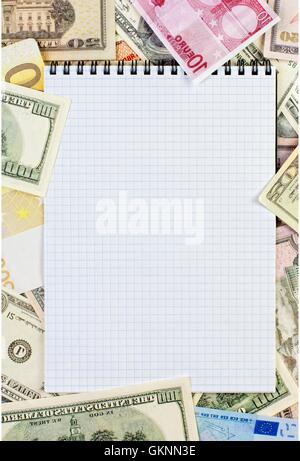 Opened spiral notepad on money background Stock Photo
