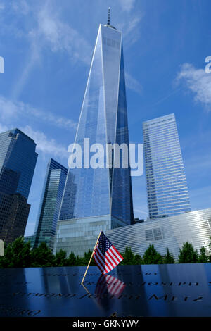 Freedom Tower, One World Trade Center  in New York, Manhattan New York. As viewed from below with an American Flag in the foreground on the 9/11 memorial. 09/08/2016 Stock Photo