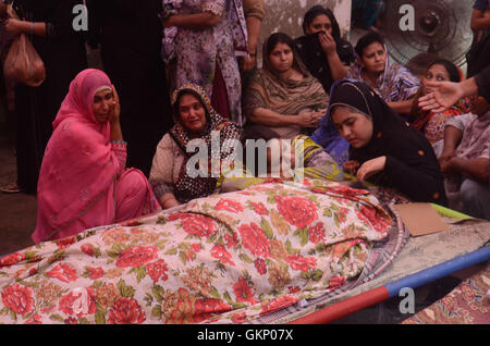 Lahore, Pakistan. 21st Aug, 2016. (Editor's Note: Image depicts death) Pakistani relatives mourn beside the dead bodies who were lost their life during old building collapsed near historical Wazir Khan Mosque Dehli gate in Lahore. Five people were killed and eight others injured when the roof of a house caved in during a wedding ceremony in Lahore on Sunday, local media reported. Credit:  Rana Sajid Hussain/Pacific Press/Alamy Live News Stock Photo