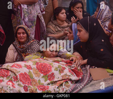 Lahore, Pakistan. 21st Aug, 2016. (Editor's Note: Image depicts death) Pakistani relatives mourn beside the dead bodies who were lost their life during old building collapsed near historical Wazir Khan Mosque Dehli gate in Lahore. Five people were killed and eight others injured when the roof of a house caved in during a wedding ceremony in Lahore on Sunday, local media reported. Credit:  Rana Sajid Hussain/Pacific Press/Alamy Live News Stock Photo