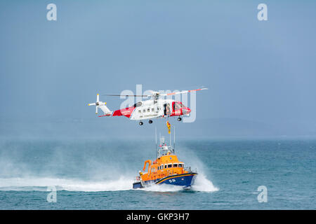 Mousehole, Cornwall, UK. 21st Aug, 2016. After a week of tragedies around the UK coast, and heroic rescues by the RNLI and the Coastguards, the Penlee Lifeboat and Coastguard helicopter display their skills for the annual fundrasing lifeboat day at Mousehole in Cornwall. Credit:  Simon Maycock/Alamy Live News Stock Photo