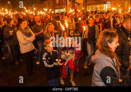 Bridport, Dorset, UK. 21st Aug, 2016. About 2,000 people with flaming torches take part in the annual Bridport Carnival Torchlight Parade which leaves from Bucky Doo Square at Bridport Town Hall and goes to the beach at West Bay over a route of one and a half miles. Picture Credit:  Graham Hunt/Alamy Live News Stock Photo