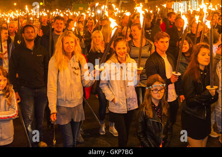 Bridport, Dorset, UK. 21st Aug, 2016. About 2,000 people with flaming torches take part in the annual Bridport Carnival Torchlight Parade which leaves from Bucky Doo Square at Bridport Town Hall and goes to the beach at West Bay over a route of one and a half miles. Picture Credit:  Graham Hunt/Alamy Live News Stock Photo