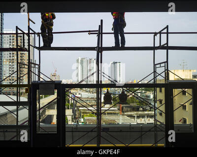 Nonthaburi, Nonthaburi, Thailand. 23rd Aug, 2016. Construction workers on scaffolding in the Tao Poon station of the ''Purple Line, '' the new Bangkok commuter rail line that runs from Bang Sue, in Bangkok, to Nonthaburi, a large Bangkok suburb. The Purple Line is run by the Metropolitan Rapid Transit (MRT) which operates Bangkok's subway system. The Purple Line is the fifth light rail mass transit line in Bangkok and is 23 kilometers long. The Purple Line opened on August 6 and so far ridership is below expectations. Only about 20,000 people a day are using the line; officials had estimate Stock Photo