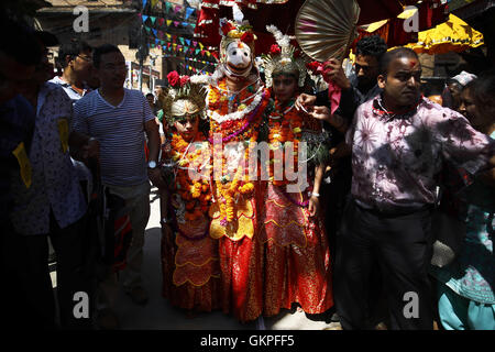 Lalitpur, Nepal. 23rd Aug, 2016. Nepalese devotees gather as people dressed as deities take part in a procession to celebrate the festival of Deity Narsingh (C) in Patan, Lalitpur, Nepal on Tuesday, August 23, 2016. Nepalese people from all over Patan of Newar community gather to offer worship by placing flowers and money to divinities as a belief to receive blessings and wellbeing of ones family. The ritual dates back to some 400 years. © Skanda Gautam/ZUMA Wire/Alamy Live News Stock Photo