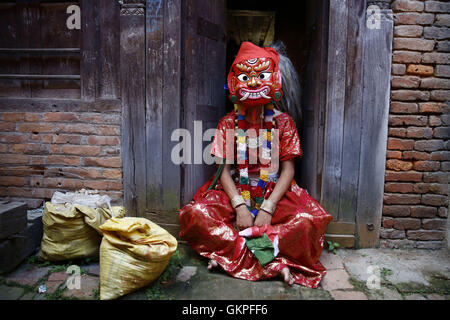 Lalitpur, Nepal. 23rd Aug, 2016. A Nepalese person dressed as a Lakhey sits before performing a traditional dance during deity procession to celebrate the festival of Deity Narsingh in Patan, Lalitpur, Nepal on Tuesday, August 23, 2016. Nepalese people from all over Patan of Newar community gather to offer worship by placing flowers and money to divinities as a belief to receive blessings and wellbeing of ones family. The ritual dates back to some 400 years. © Skanda Gautam/ZUMA Wire/Alamy Live News Stock Photo