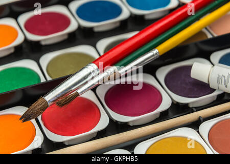 new unused palette of multicolor watercolor paints with paint brushes Stock Photo