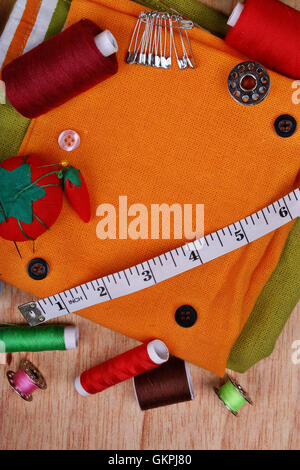 Background vertical with sewing items: buttons, colorful fabrics, material, measuring tape, bobbins, buttons, cloth, safety pins Stock Photo