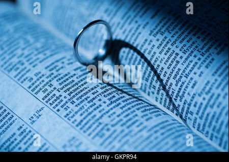 golden ring makes heart shaped shadow in book Stock Photo