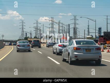 New Jersey Turnpike cars with electricity pylons and power lines along the road Stock Photo