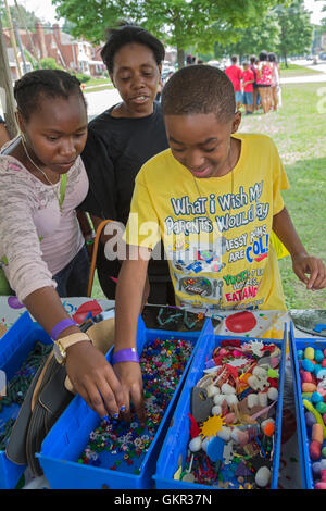 Detroit, Michigan - Neighborhood groups hold a summer street fair. Children use scrap materials to make art projects. Stock Photo