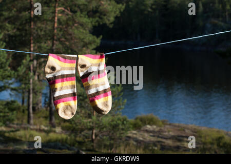 Bright socks drying after washing on the clotheline outdoors. Stock Photo