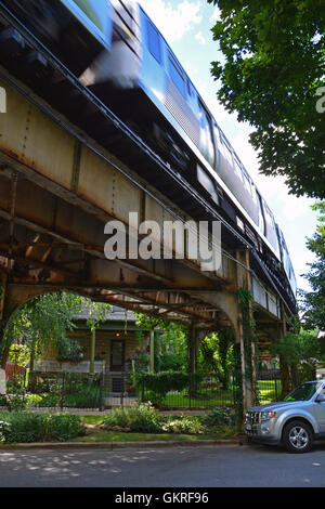 The Brown Line elevated CTA train tracks passing through yards in the residential neighborhood of Ravenswood in Chicago. Stock Photo