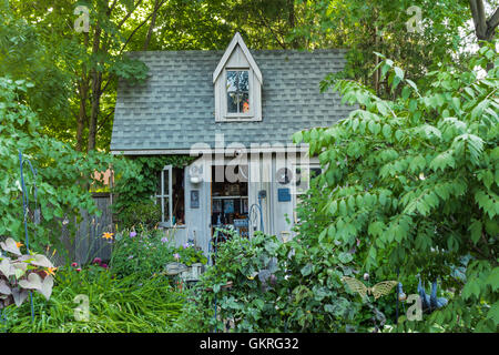 Large garden shed with dolls face in the window Stock Photo