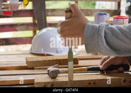 Carpenter using  chisel and hammer in his hand with plank.Close up and stillife Stock Photo