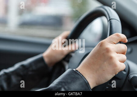 Driving a car, hands on steering wheel Stock Photo