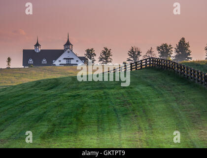 Black Fence Leads over the Hill in Kentucky horse country Stock Photo