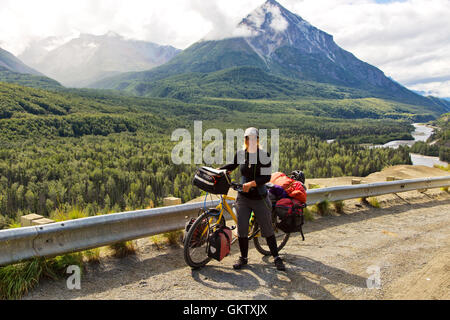 Young woman from Germany  biking, highway AK1, Alaska. Stock Photo