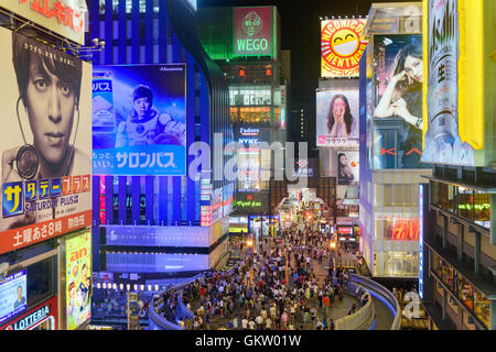 OSAKA, JAPAN - AUGUST 16, 2015: Pedestrians on Ebisu Bridge pass over Dotonbori Canal in the Namba District. The canals date fro Stock Photo