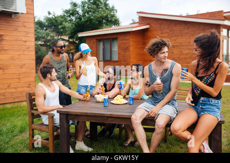 Group of happy young people drinking beer and having outdoor summer party Stock Photo