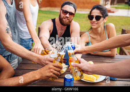 Cheerful young friends celebrating and drinking beer outdoors Stock Photo