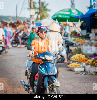 Young woman on scooter shopping at street market Stock Photo