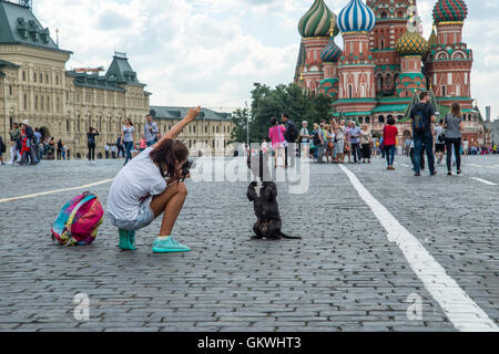 Girl photographing her dog in front of the St. Basil's Cathedral in Moscow Stock Photo