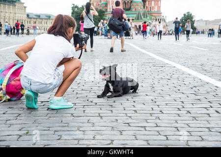 Girl photographing her dog in front of the St. Basil's Cathedral in Moscow Stock Photo