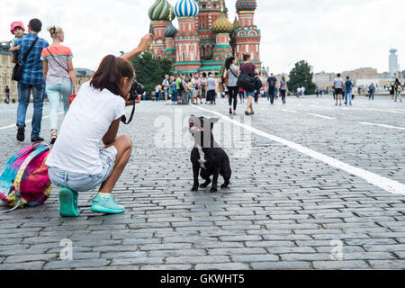 Girl photographing her dog in front of the St. Basil's Cathedral in Moscow Stock Photo