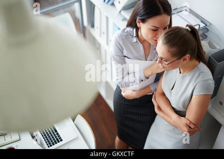 Two females gossiping in office Stock Photo