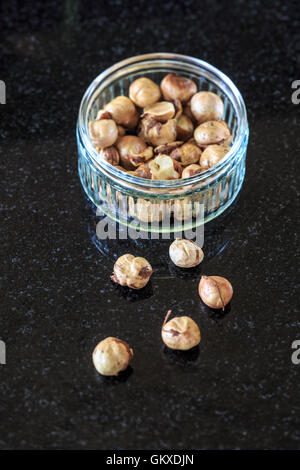 Roasted and Shelled Fresh Cob nuts In Glass bowl on dark background Stock Photo