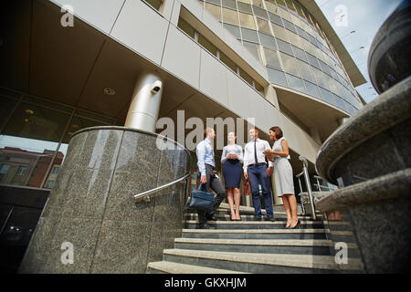 Colleagues standing on stairs in front of office center Stock Photo