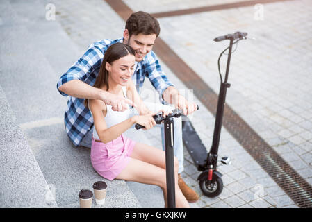 Cheerful friends using scooter Stock Photo