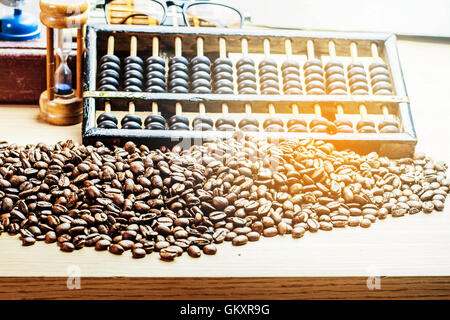 Coffee beans and abacus on a desk. Stock Photo