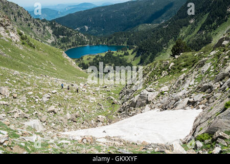 Summer hiking in Ariege area of Pyrenees,South of France. Hiking to Lake,Etang de Laurenti and Col de Laurenti. Snow on slope. Stock Photo