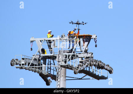 El Alto, Bolivia, 23rd August 2016. Technicians grab a drone that is being used to carry a light synthetic cable between the pylons of a new cable car / gondola lift currently under construction between Rio Seco and La Ceja in El Alto. This is the first part of the process to install the final steel cable that will carry the gondolas. This cable car is one of a second phase of cable car lines that are part of an ambitious project to relieve traffic congestion. 3 routes from the first phase are already operating between the cities of La Paz and El Alto. Credit:  James Brunker / Alamy Live News Stock Photo