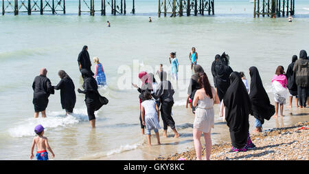 Brighton, UK. 24th Aug, 2016. UK Weather: Crowds flock to Brighton beach including Muslim women wearing tradition burkas hijabs and chadoors  to enjoy the hot sunshine today with temperatures forecast to reach over thirty degrees centigrade as the heatwave weather continues throughout southern Britain Credit:  Simon Dack/Alamy Live News Stock Photo