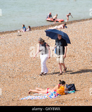 Brighton, UK. 24th Aug, 2016. This couple prefer to stay in the shade as crowds flock to Brighton beach to enjoy the hot sunshine today with temperatures forecast to reach over thirty degrees centigrade as the heatwave weather continues throughout southern Britain Credit:  Simon Dack/17�Թ����� Live News Stock Photo