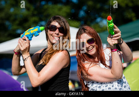 Uebersee, Germany. 24th August, 2016. Friends Jill (l) and Kathi splash with water pistols in the campsite at the festival Chiemsee Summer at Uebersee in Germany, 24 August 2016. The festival lasts from 24 August until 27 August 2016. Photo: MATTHIAS BALK/ dpa/Alamy Live News Stock Photo