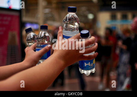 London, UK. 24th August 2016 Free emergency water handed out by members of rail company staff to help overheated commuters. Many SouthEastern trains don’t have airconditioning. Credit:  Daniel Markham/Alamy Live News Stock Photo
