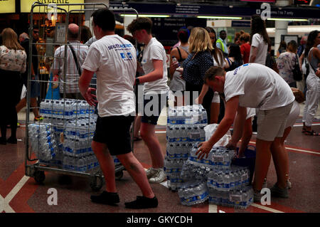 London, UK. 24th August 2016 Free emergency water handed out by members of rail company staff to help overheated commuters. Many SouthEastern trains don’t have airconditioning. Credit:  Daniel Markham/Alamy Live News Stock Photo