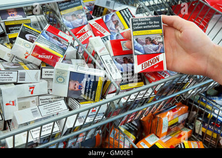 Cigarettes in an Aldi supermarket with pictures on cigarette packs to illustrate the dangers of smoking Stock Photo